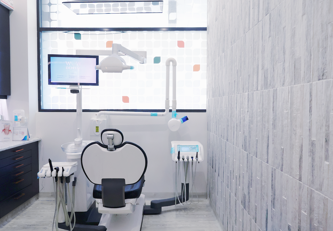 WOW Dental 诊疗室，窗前的牙科治疗椅、显示屏与诊疗设备